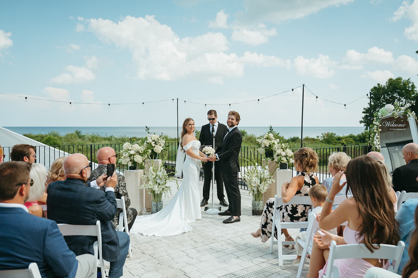 Guests seated on the upper patio for a ceremony with Lake Huron stretching to the horizon