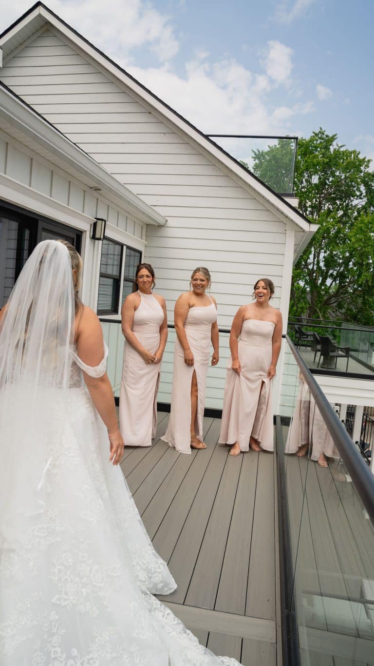 The bridal party gathered on the lawn outside the white estate house