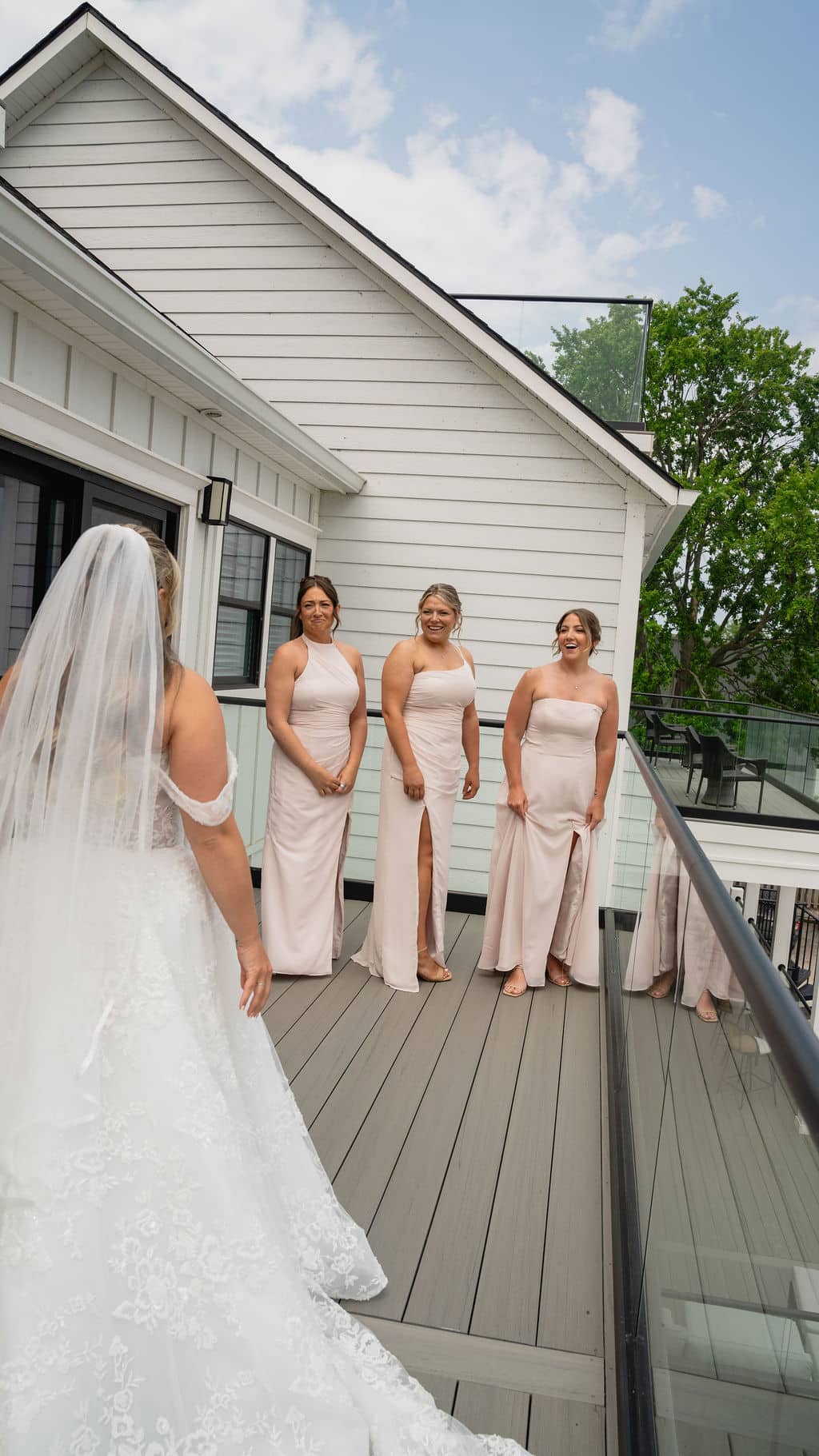 The bridal party gathered on the lawn outside the white estate house
