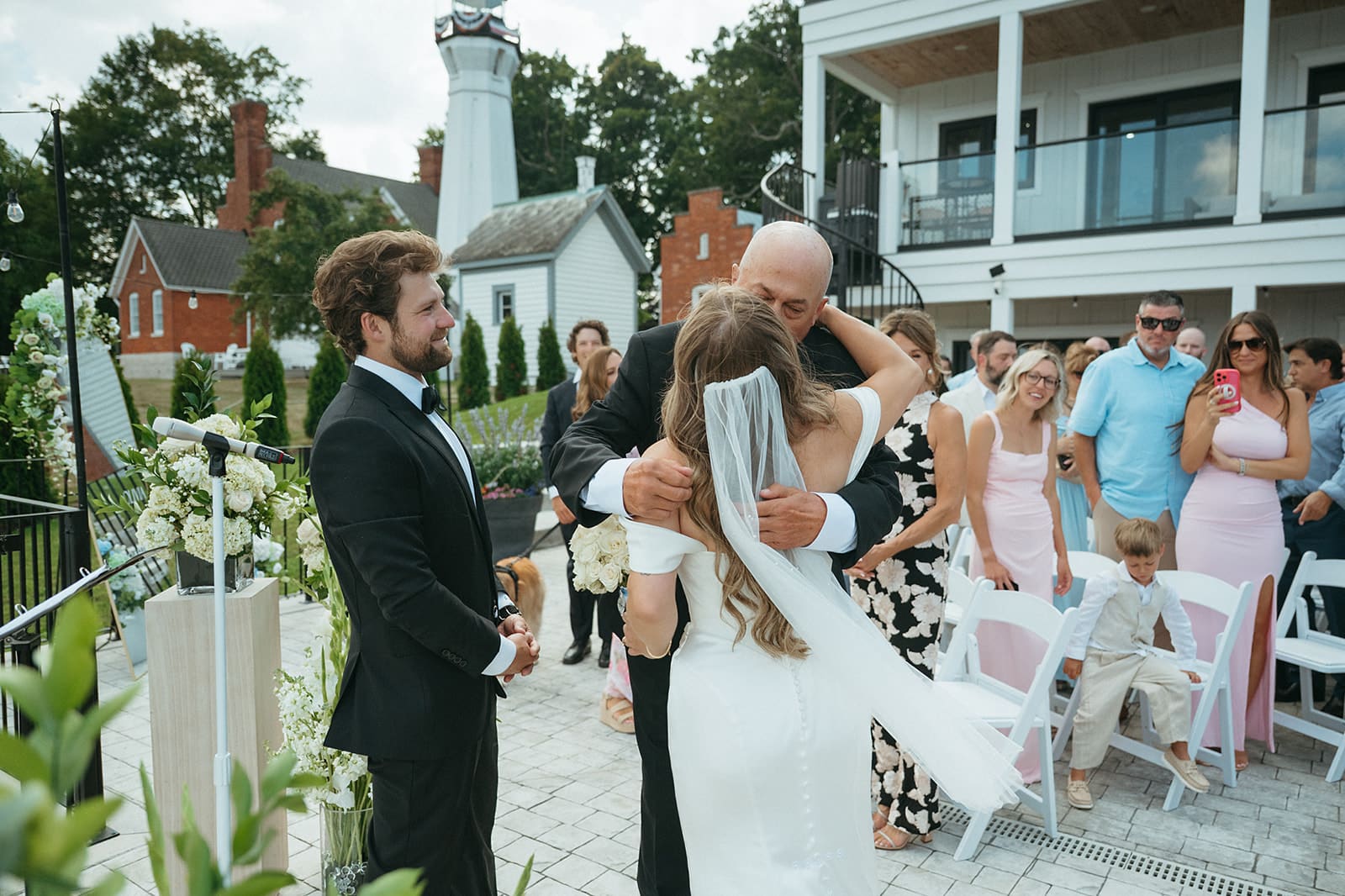 Newlyweds walking back down the aisle as guests cheer on the patio