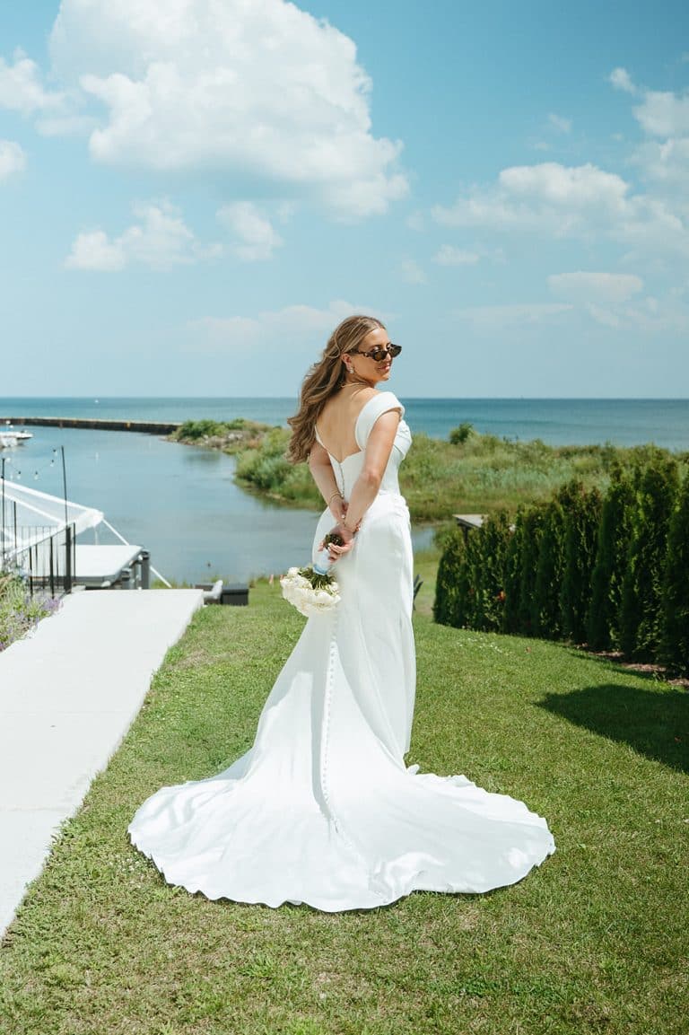 A bride walking toward the water on the estate lawn