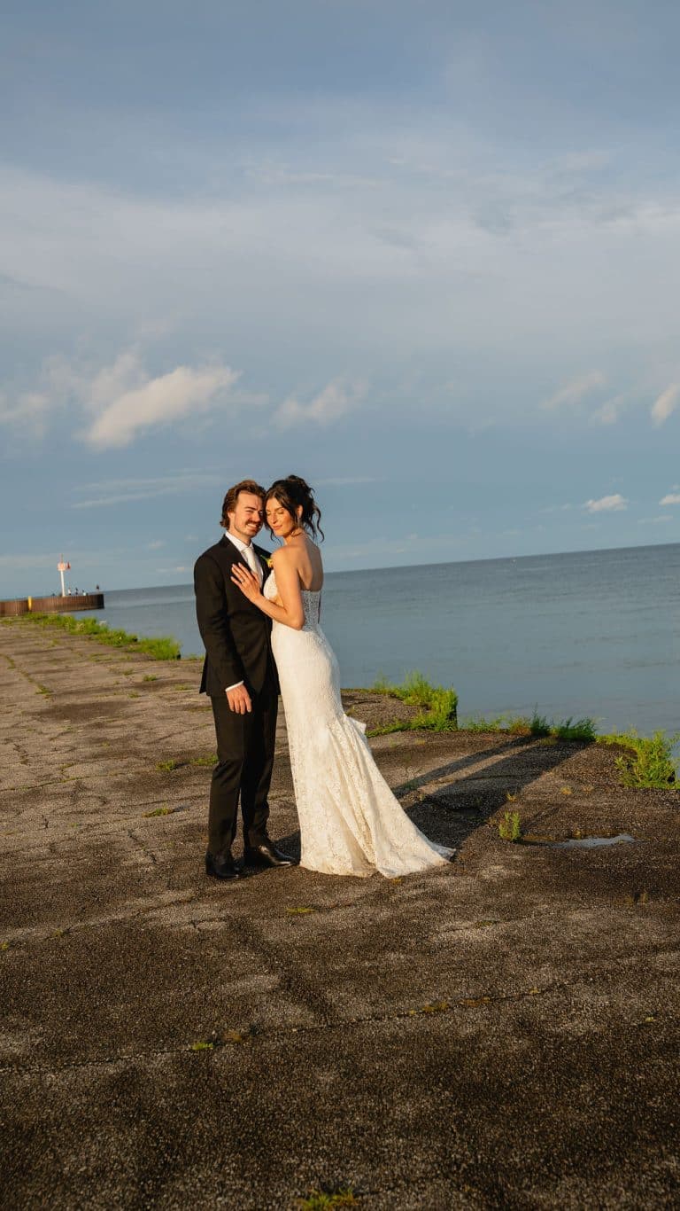 A couple embracing at golden hour on the shore of Lake Huron