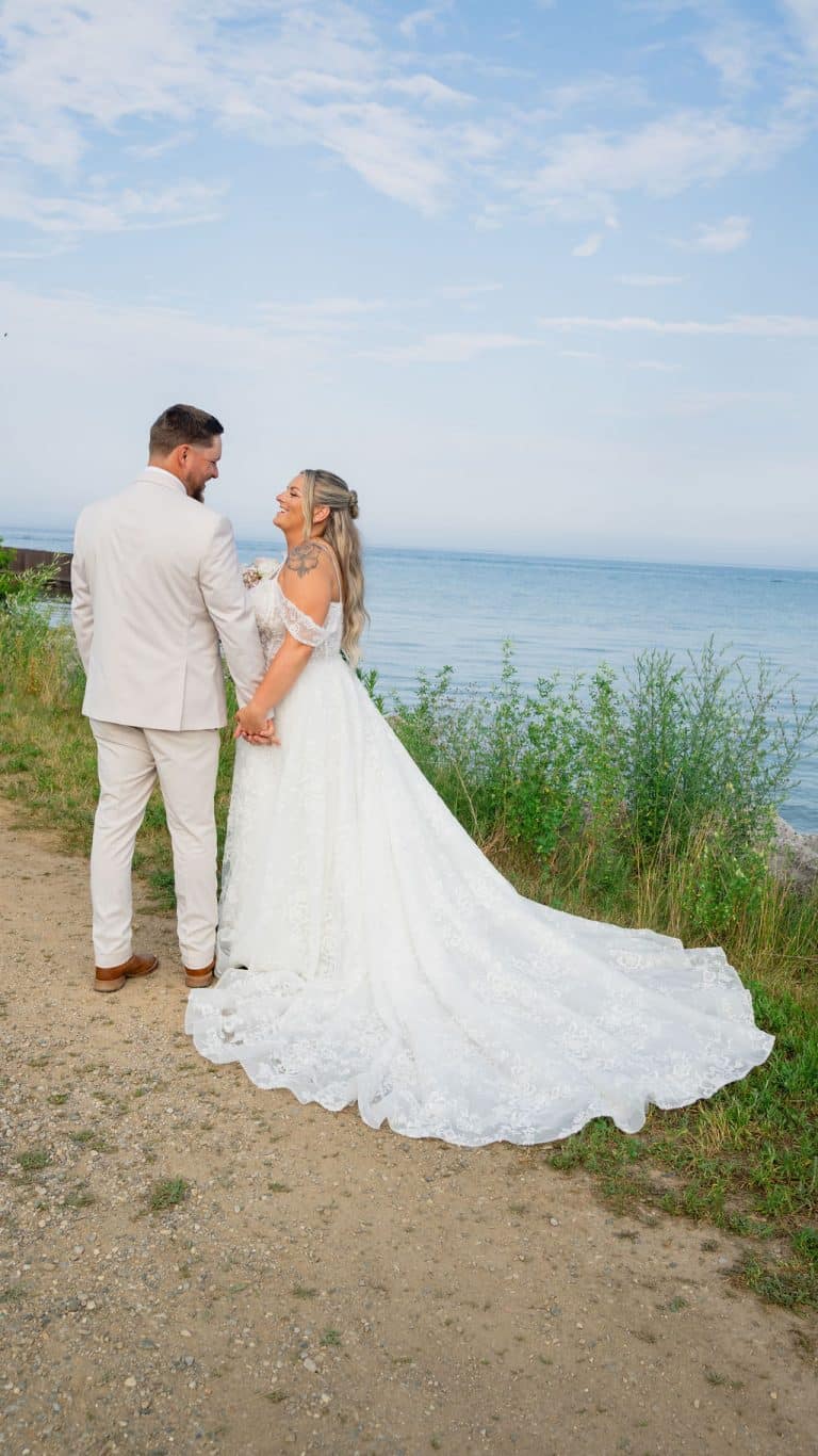 A bride and groom on the bluff with Lake Huron stretching behind them