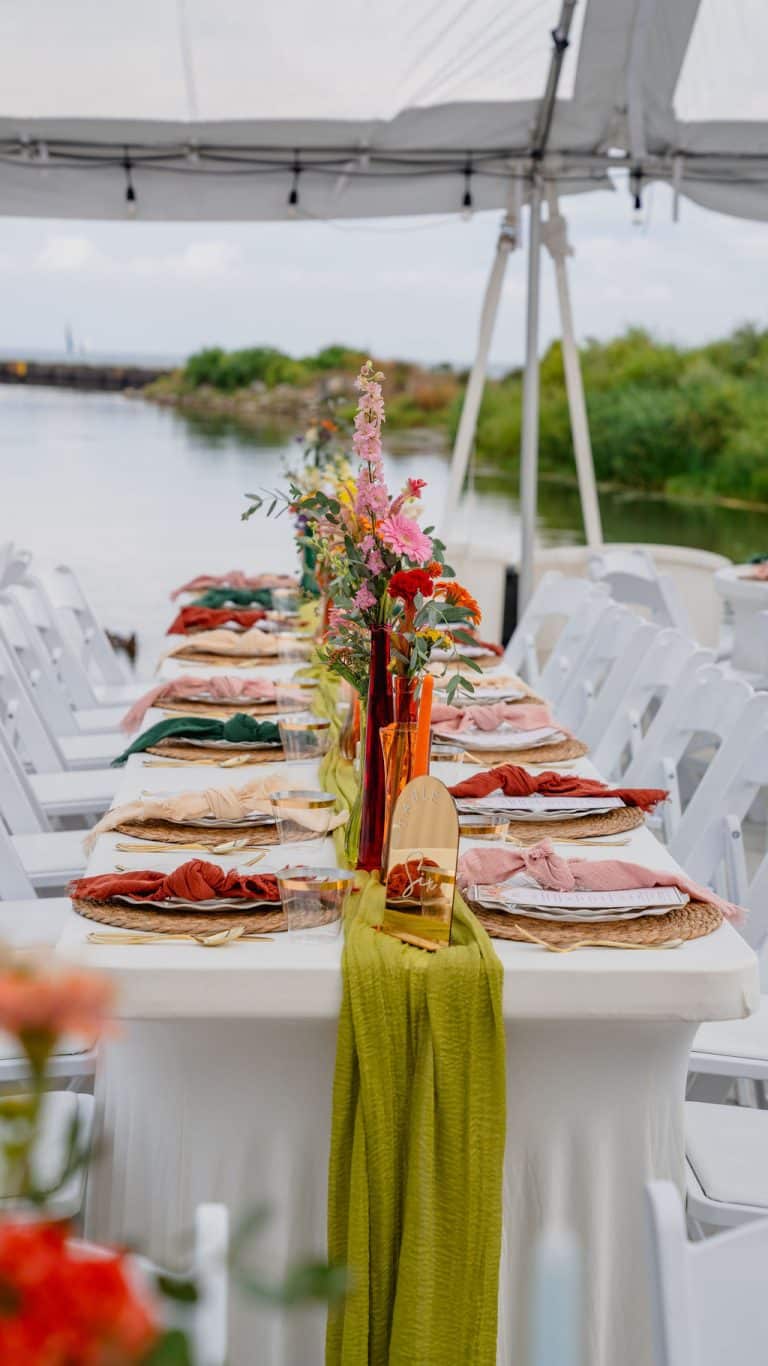 A long reception table dressed in colorful florals