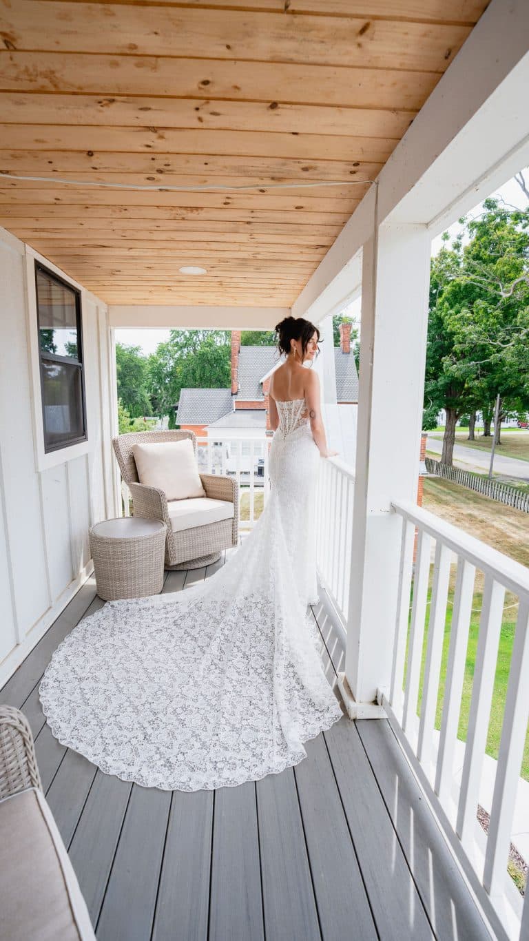 A bride on the estate's covered porch, her train spread behind her